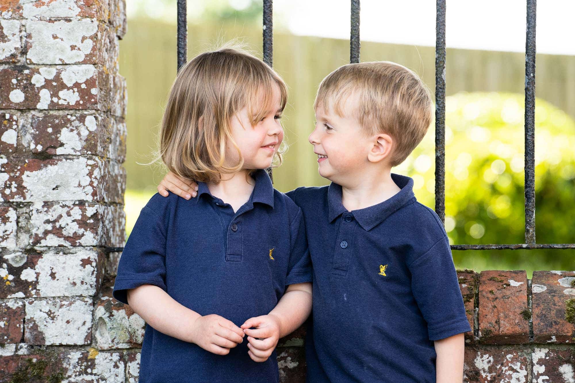 Ardingly Nursery pupils embracing and smiling in an outdoors setting.