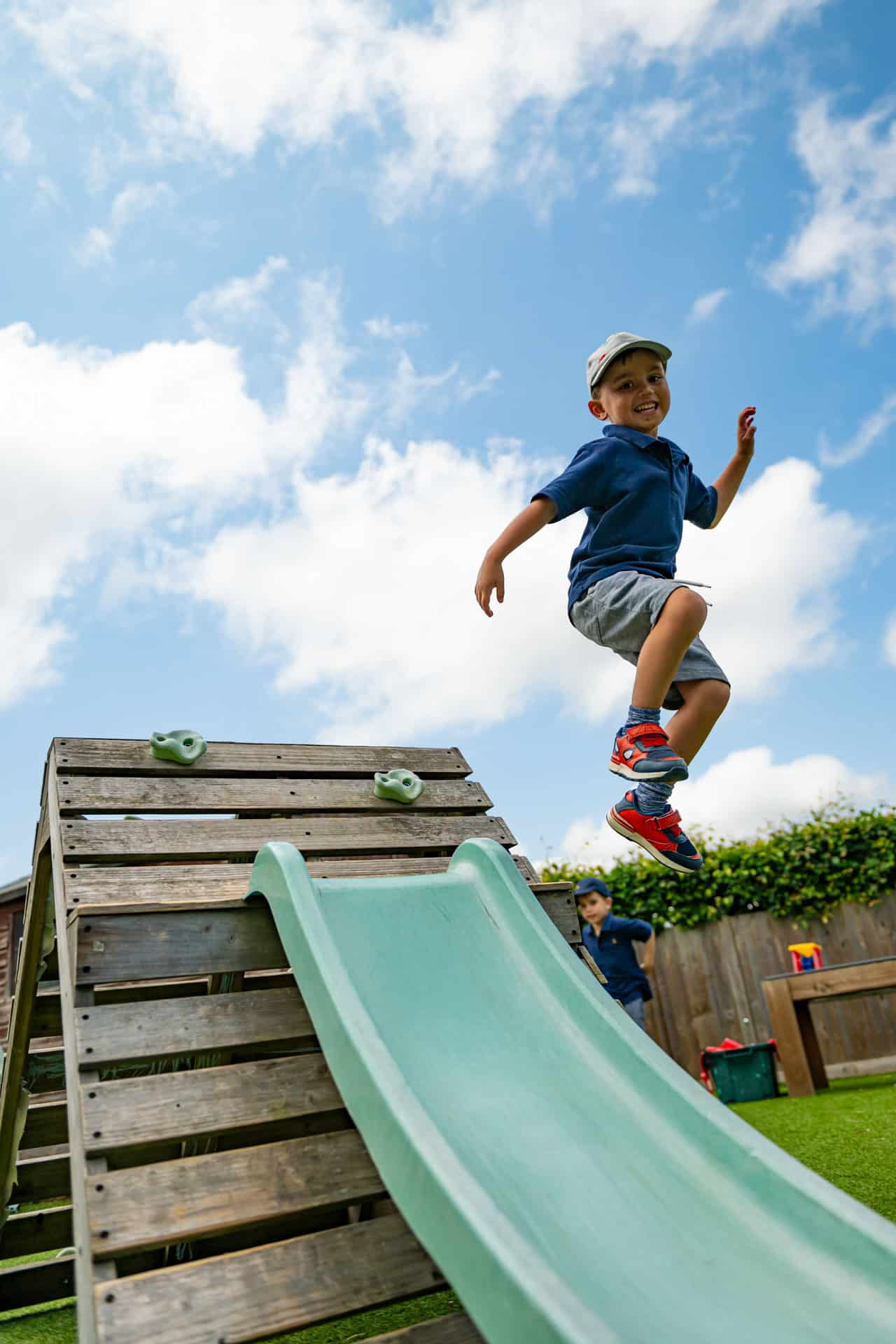 Nursery child jumping off slide