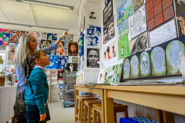 Prep school children looking at a senior school art exhibition