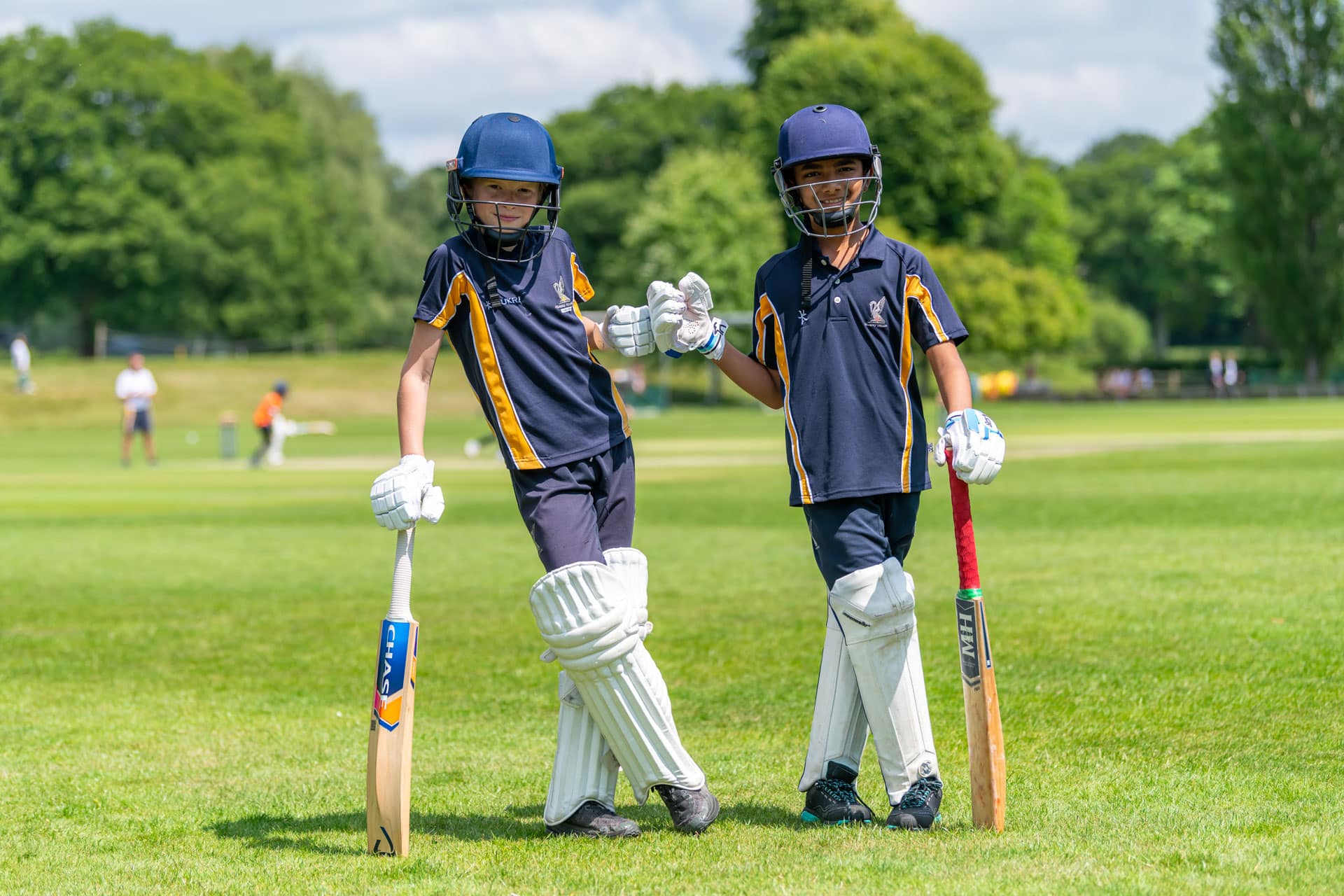 Prep boys bumping fists in their cricket gear