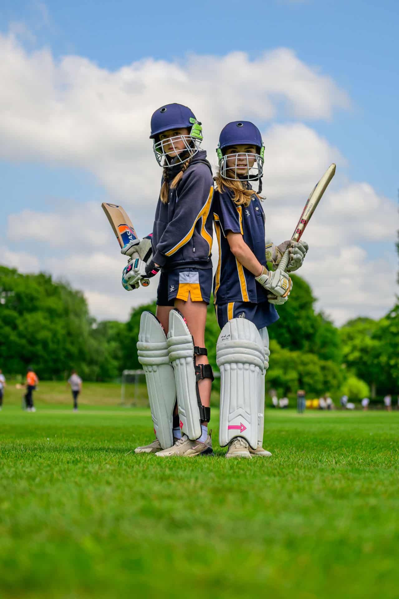 Prep girls standing back to back in cricket gear