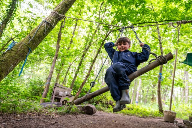 Prep child on a swing at forest school