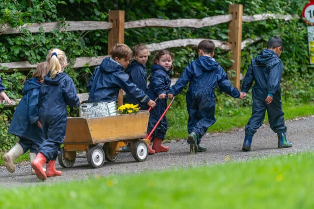 Prep children pulling a wooden trolley to forest school