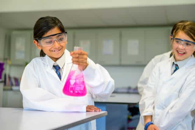 Girl holds a flask in a science lab