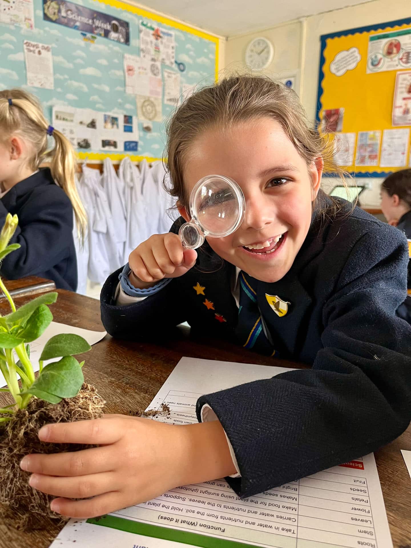 girl looking in a magnifying glass in the science lab