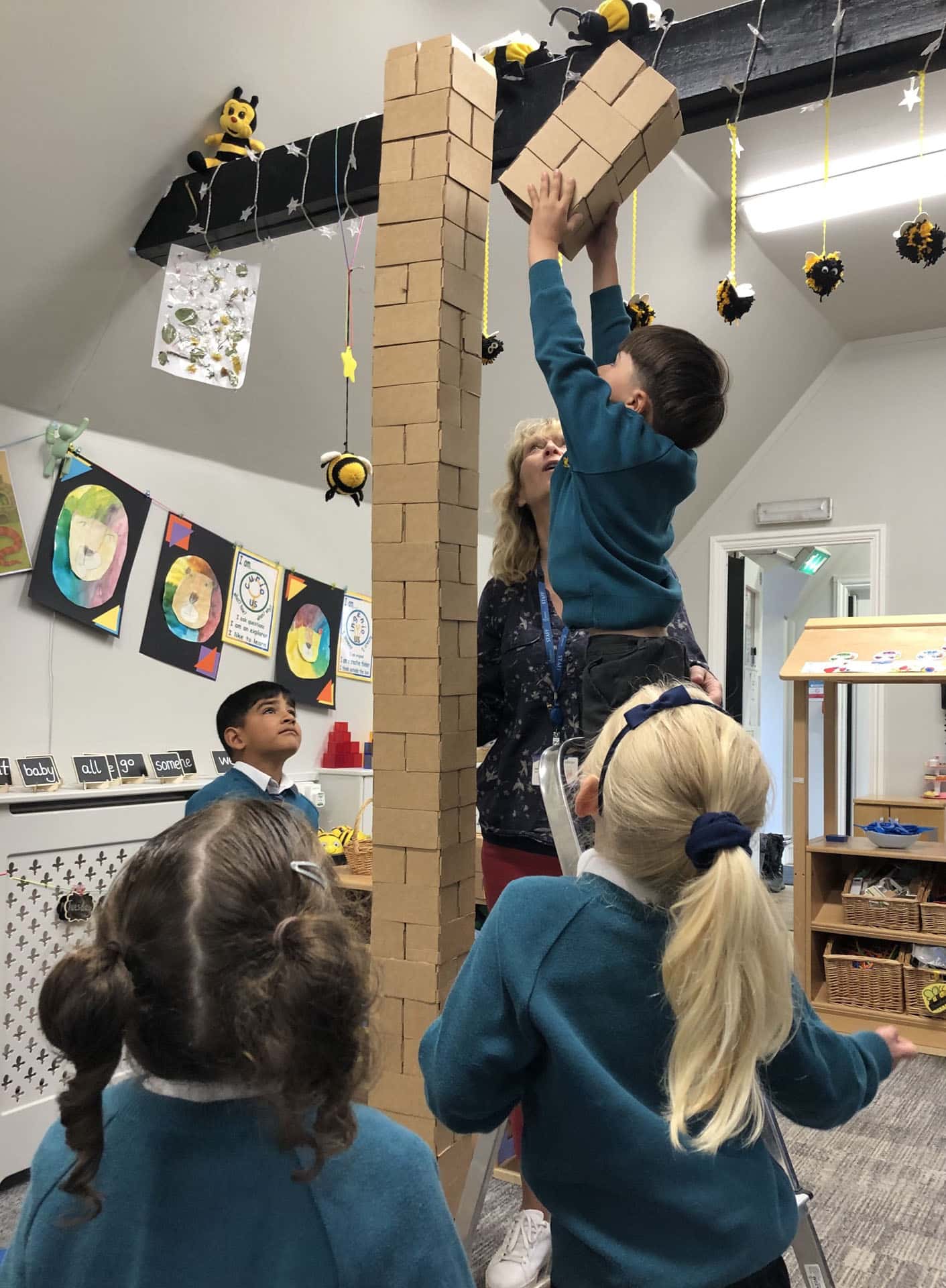 Reception children building a tower in the classroom