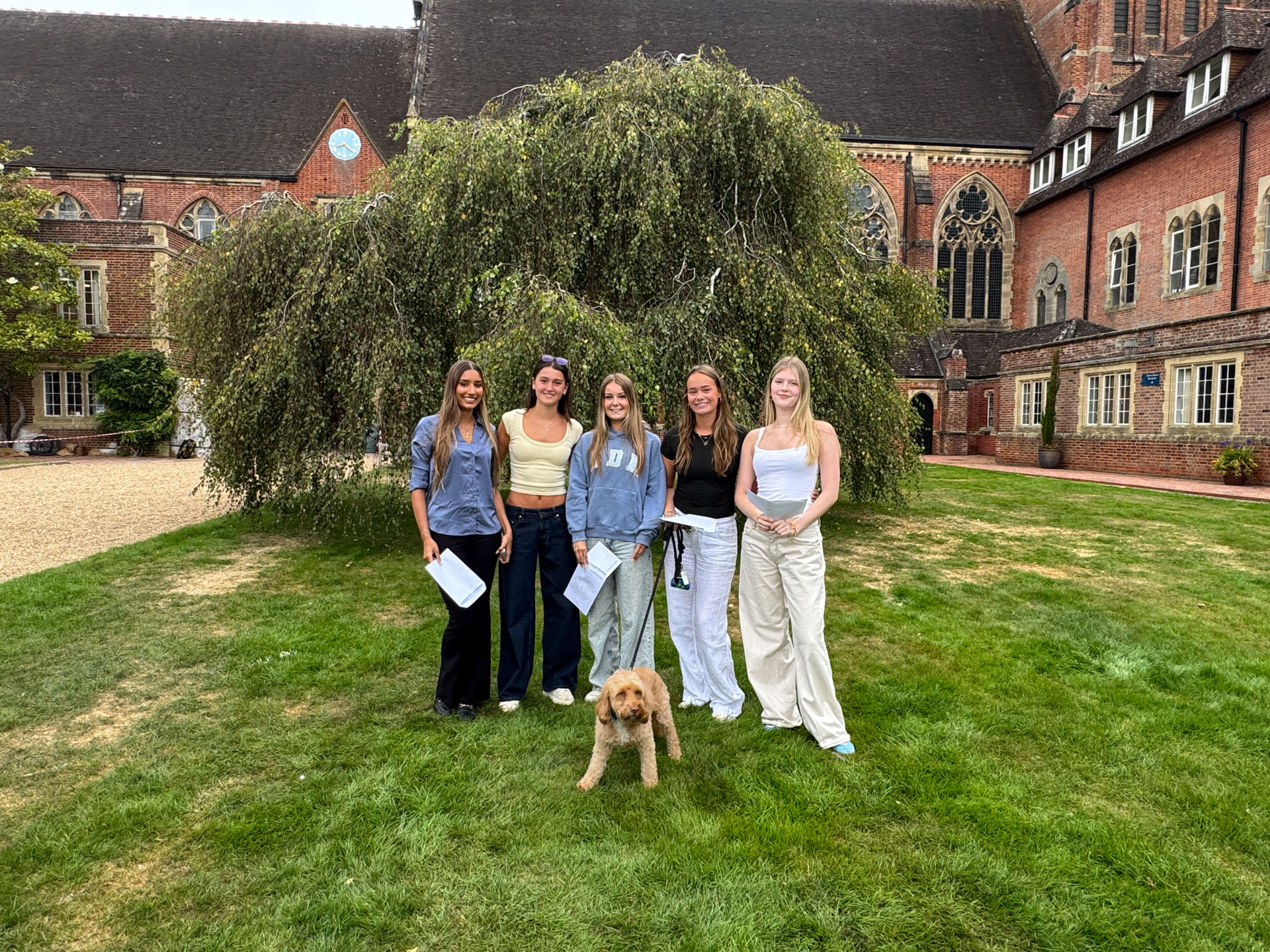 Five female students in front of the College building after getting their A Level results.