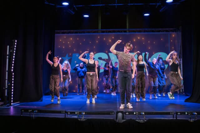 Lead male dancer in a contemporary group piece from Lost in Motion 2025.
