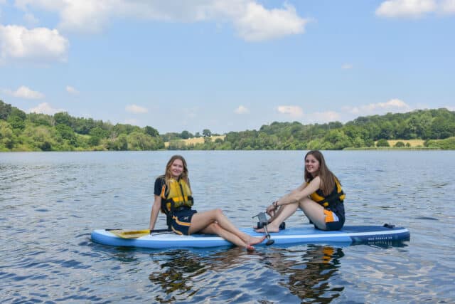 Girls enjoying themselves on a paddleboard at Ardingly Reservoir