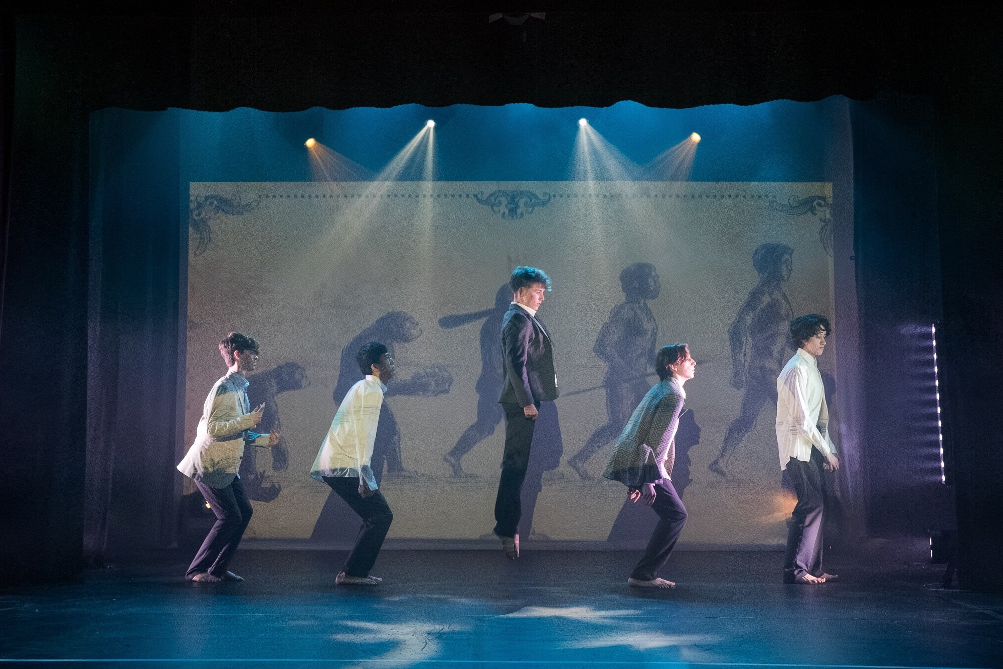 Five male dancers performing an evolution scene