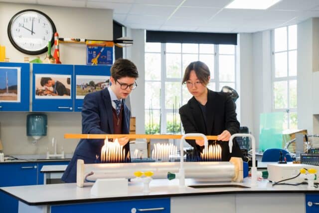 Two Sixth Form Physics students conducting an experiment