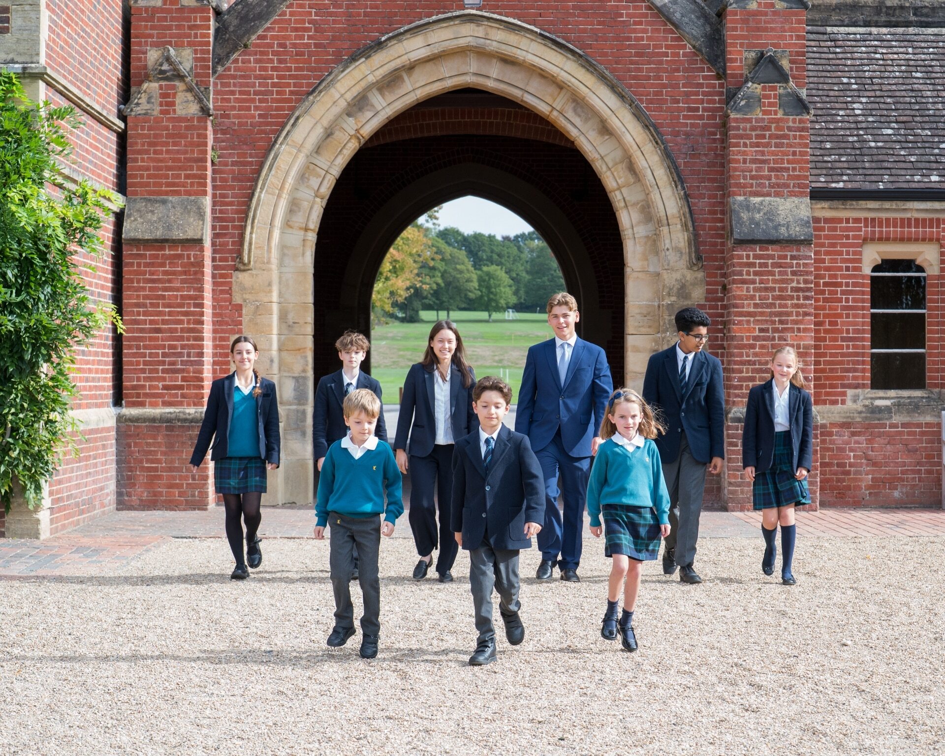 Students and children at Ardingly College walking through the arch